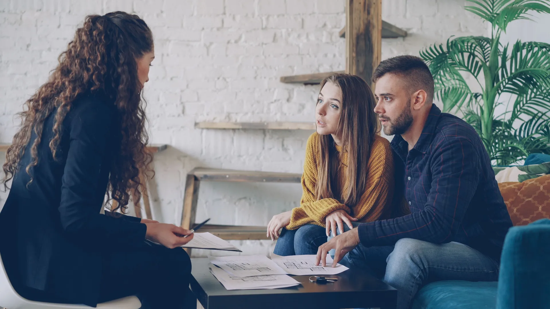 A professional consultant meeting with a couple in a modern office setting
